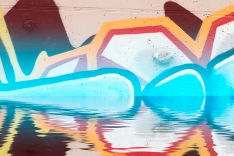 Graffiti wall texture reflection in  water, artistic urban picture Illustrazione stock