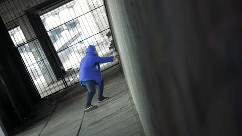 Graffiti. A young guy draws on the wall. Stock Footage 83160240