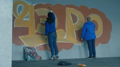 Graffiti. A young guy draws on the wall. Stock Footage 83160574