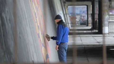 Graffiti. A young guy draws on the wall. Stock Footage 83160656