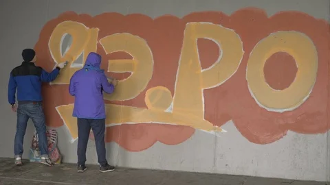Graffiti. A young guy draws on the wall. Stock Footage 83160850