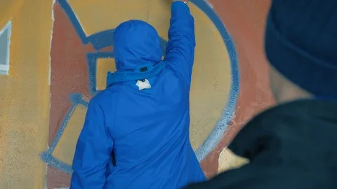 Graffiti. A young guy draws on the wall. Stock Footage 83161121