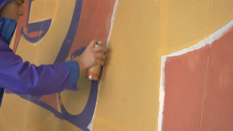 Graffiti. A young guy draws on the wall. Stock Footage 83161158