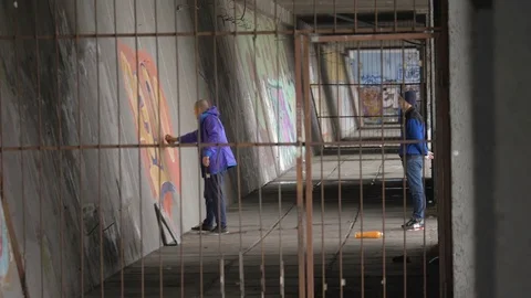 Graffiti. A young guy draws on the wall. Stock Footage 83161295