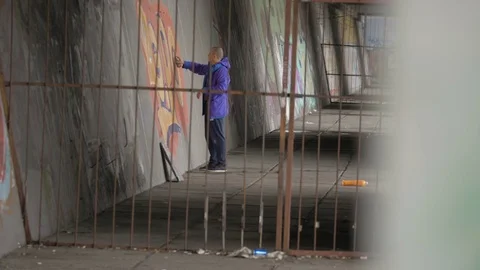 Graffiti. A young guy draws on the wall. Stock Footage 83161319