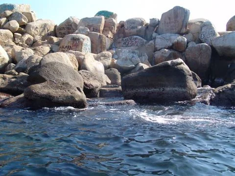 Graffitis on rock in the ocean 02 Stock Photos