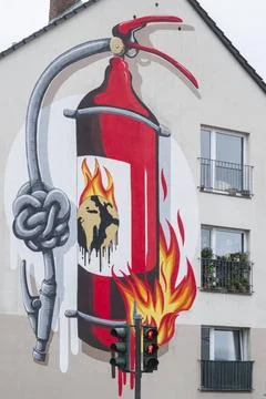 Graffito an einer Hauswand zeigt einen brennenden Feuerlöscher und einem .. Foto stock