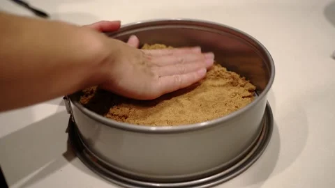 Graham cracker mound pressed into pie crust Stock Footage 222166314
