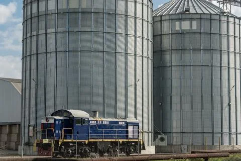 Grain is being prepared for storage as a train engine waits beside large si.. Stock Photos
