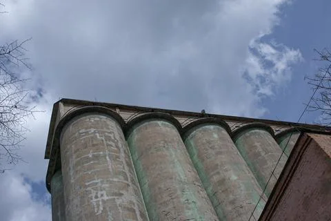 Grain elevator against a stormy sky. Large factory structure against a blue.. Stock Photos