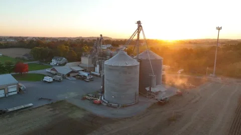 Grain elevator bins for corn and soybean crop at sunset. Aerial orbit. Stock Footage 220771907