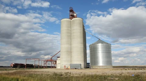 Grain elevator with dramatic clouds and freight train. Saskatchewan, Canada. Stock Footage