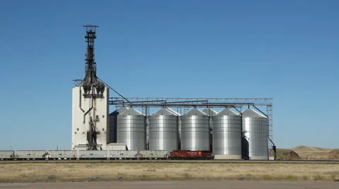 Grain elevator with freight train and loco. Alberta, Canada. Traffic going by. Stock Footage 52137286