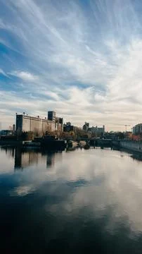 The grain elevator standing on the bank of the river 스톡 사진