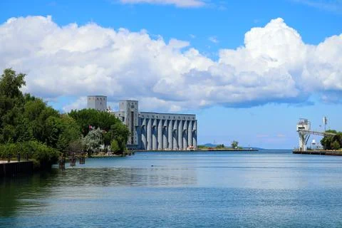 Grain elevators at the mouth of the harbour on a clear sunny day Stock Photos