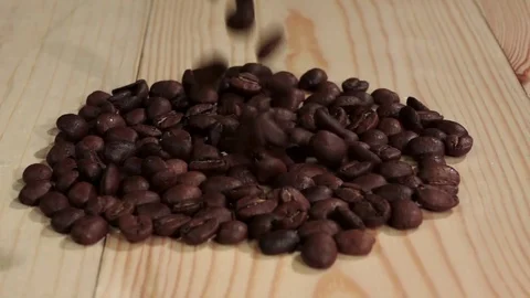 Grain of fresh coffee falls on the table and crumbles. Close up. Slow motion Stock-Footage 74735564