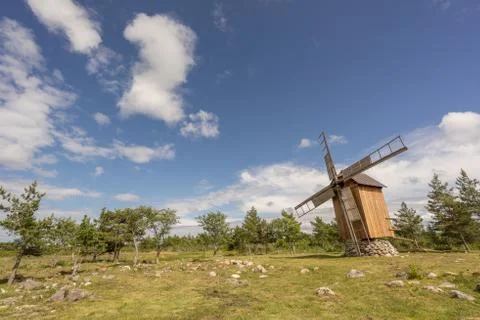 Grain mill on the summer landscape. Windmill and natural background pattern.  Stock Photos