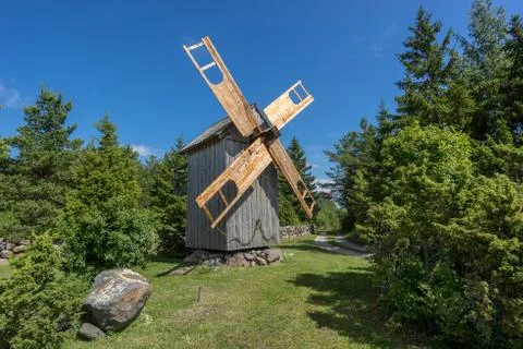 Grain mill on the summer landscape. Windmill and natural background pattern.  Stock Photos
