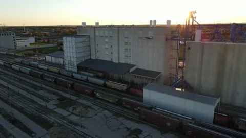 Grain silos and elevator at train yard with multiple freight cars and tracks Stock Footage 163872190
