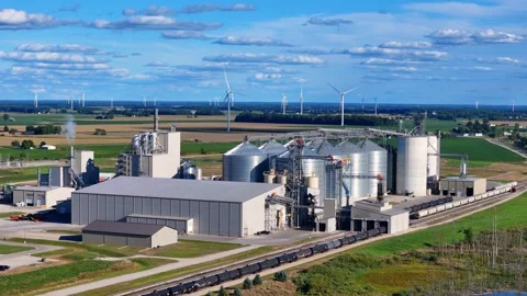 Grain silos and elevators with wind turbines and railway in Ithaca, Michigan Stock Footage 325960937
