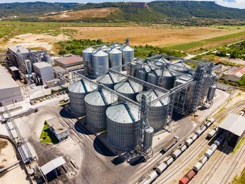 Grain silos stand tall within an industrial site located in a rural area. Tra 스톡 사진