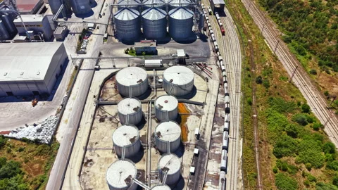 Grain storage facility with silos and train tracks in an industrial area on a Stock Footage 341074274