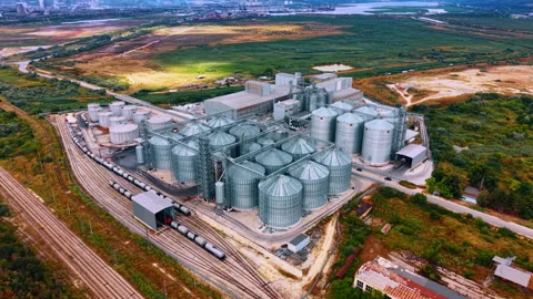 Grain storage facility with silos and train tracks near a river. A large grain Stock Footage 342734849
