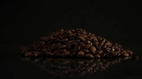 Grains of coffee on a black background. A soft light illuminates the grains. Stock-Footage 98856404