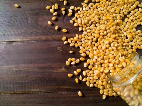 Grains of corn on wooden table Stock Photos