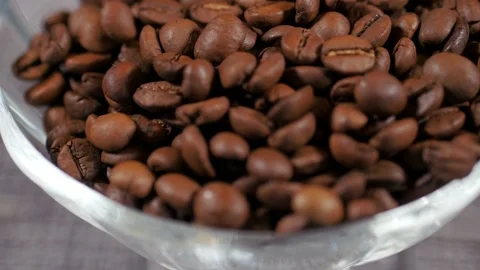 Grains in a glass cup. Background consisting of roasted coffee beans. Stock Footage 152045276