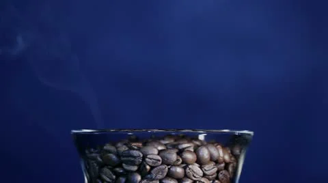 Grains of the roasted coffee in a glass with a smoke Stock Footage