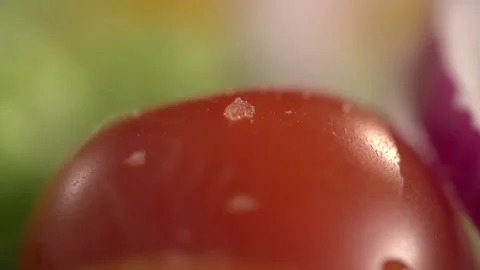 Grains of salt fall on a tomato on a close-up Stock Footage 95527056