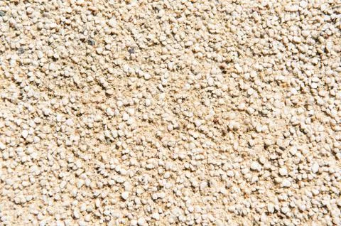 Grainy texture of decorative plaster. Tiny grains little stones in cement or Stock Photos