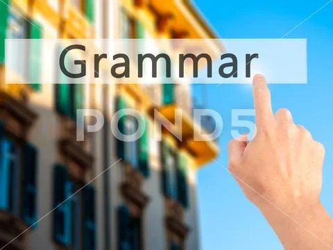 Grammar - Hand pressing a button on blurred background concept o Stock Photos