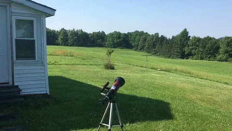 A grand backyard landscape with a red telescope and red barn Stock Footage