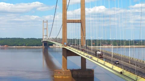 Grand bridge spans wide river with gentle waves Vidéo 343529025
