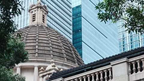A grand classical building with a small decorative cupola set against modern Stock Footage 338165460