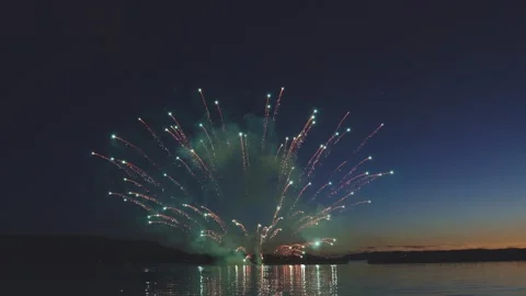 Grand golden fireworks exploding in fan shape over sea Stock Footage 340632692