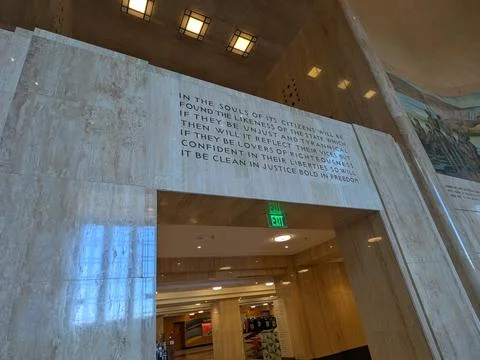 Grand marble corridor featuring an engraved civic quote Фото