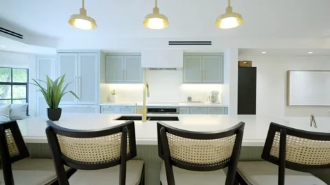 Grand modern kitchen having elegant white and tranquil light blue cabinets, gold Stock Footage 242943847