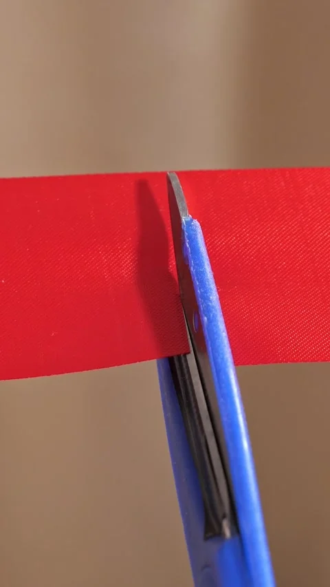 Grand opening ceremony featuring blue scissors cutting through a vibrant red Video stock 342908648