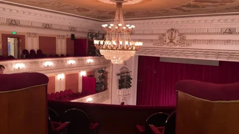 The grand opera hall glows under a massive crystal chandelier as the symphony Stock-Footage 306007193