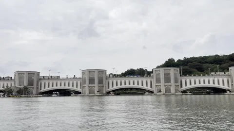 Grand stone bridge spans wide river under cloudy sky Stock Footage 340034428