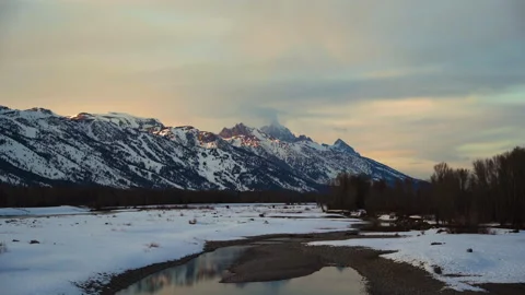 Grand teton mountain range looking over snowy plains with winter snowy river Stock Footage 150778518