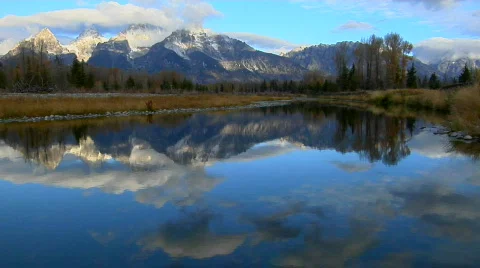 The Grand Teton mountains are reflected in a mountain lake. Stock Footage