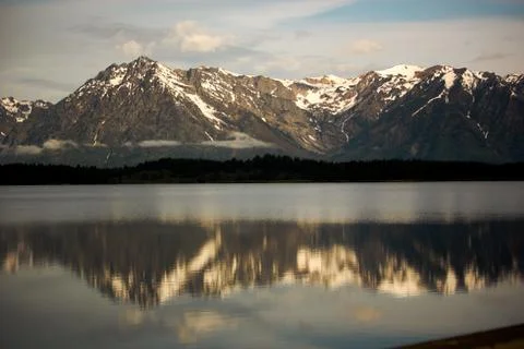 Grand Tetons Mountain Range Reflected in a Lake at Sunrise Stock Photos
