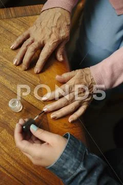 Granddaughter Applying Painting Fingernails Of Grandmother