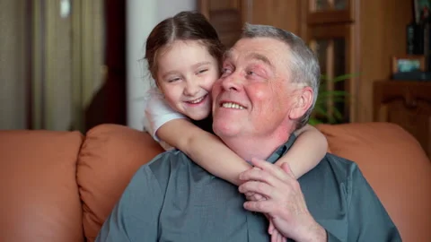 The granddaughter hugs an senior 60s grandfather. They are happy and smiling Stock Footage