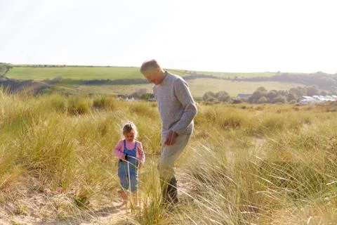 Grandfather And Granddaughter Collecting Litter On Winter Beach Clean Up Stock Photos