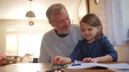 Grandfather And Granddaughter Colouring Picture Together Stock Footage